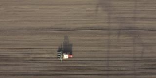 俯视图的拖拉机拖动播种机在农业领域，农田