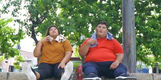 疲惫超重的夫妇坐在公园里