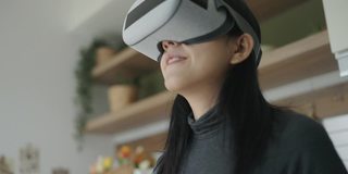 亚洲女性在家里使用VR眼镜