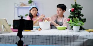 圣诞节期间，亚洲孩子们在家里拍摄饼干烹饪视频制作视频，或者在家里一起拍TikTok，这是新一代概念的时尚生活方式。