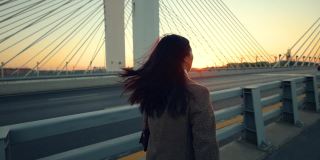 日落时分，一个女人走在桥上