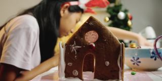 亚洲的孩子们晚上在家里一起做姜饼屋，庆祝圣诞节的生活理念。