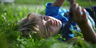 那孩子躺在草地上玩耍，做着白日梦