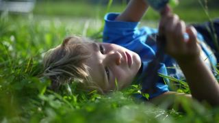 那孩子躺在草地上玩耍，做着白日梦视频素材模板下载
