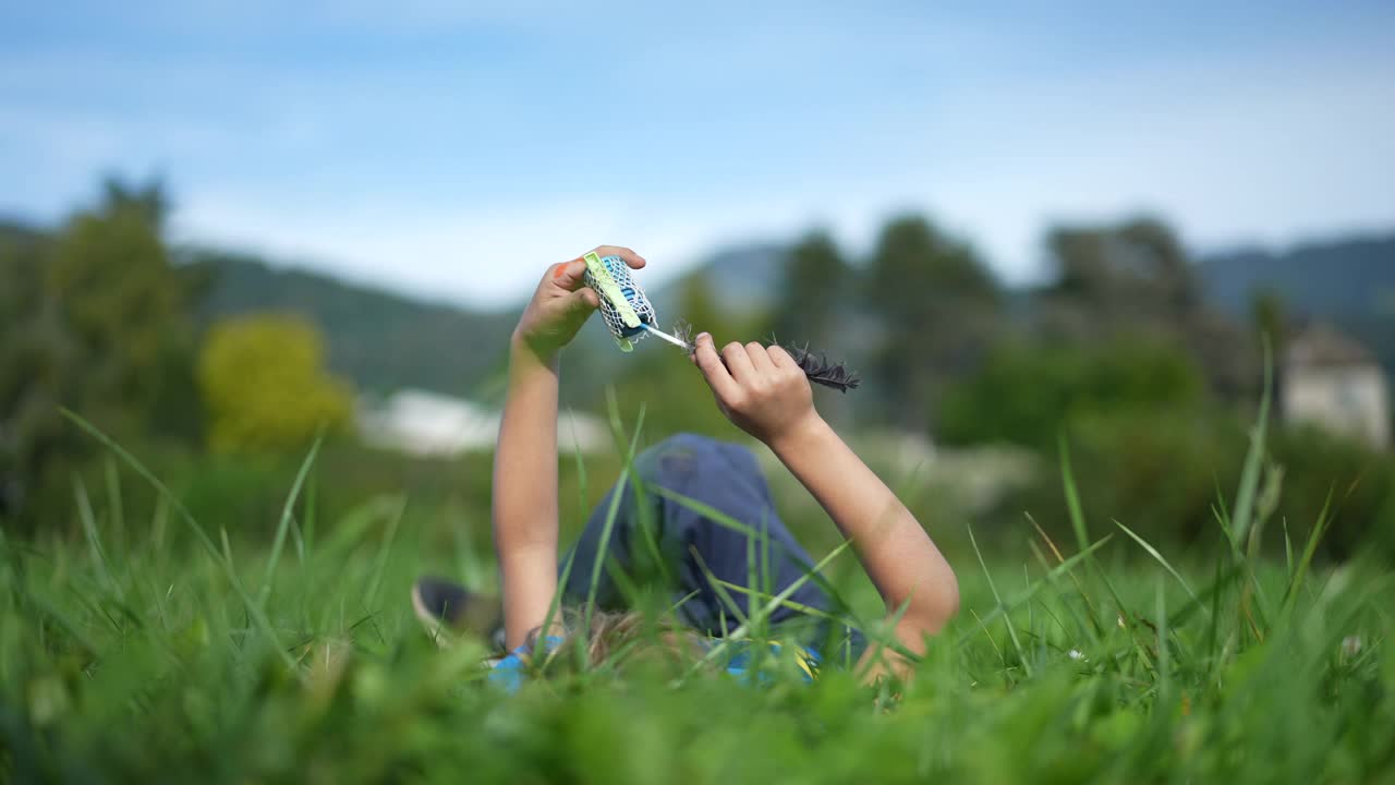 孩子躺在外面的草地上做着白日梦玩耍