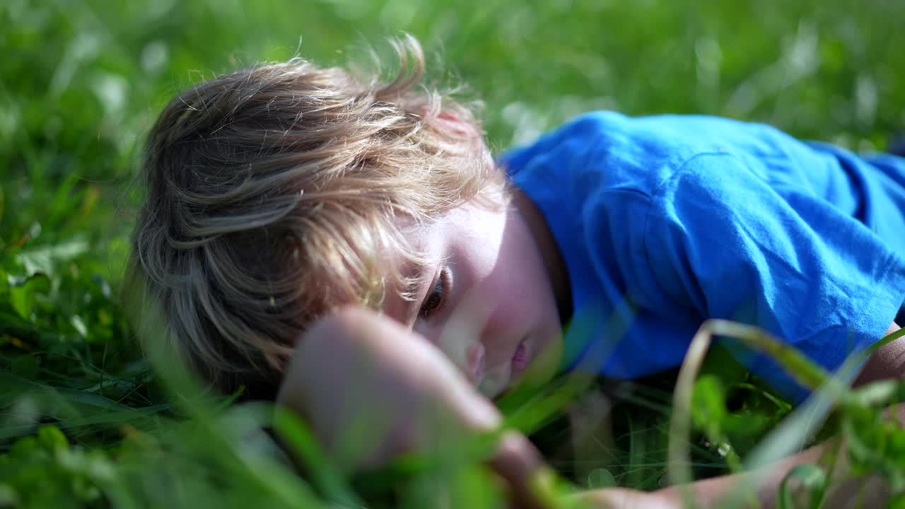 孩子躺在外面的草地上做着白日梦玩耍