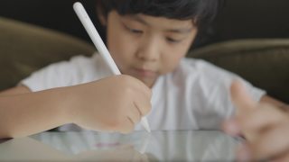 亚洲男孩数字艺术家绘画在一个图形平板电脑。视频素材模板下载