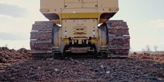 履带式推土机在建筑工地或采石场工作的跟踪镜头。矿山机械搬运粘土，平整砾石路面，用于新建道路。土方，挖掘，在土壤上挖掘。