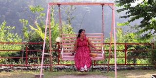 印度瑞诗凯诗，Shivpuri，年轻女子在大自然中享受门廊秋千