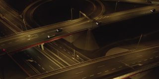 鸟瞰图的高速公路和交叉口的道路，桥梁，高架桥在夜间，城市地区的交通和基础设施的发展。