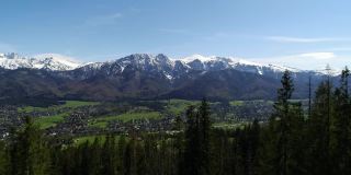积雪覆盖的高山鸟瞰图。阳光明媚的泰特拉山，绿树和落基山脉的景色。青山山谷和雪山。