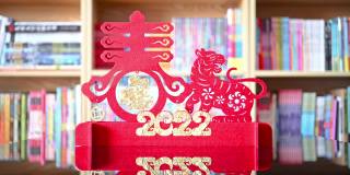 放大img在中国新年的老虎剪纸2022吉祥物在客厅的书架前的中文翻译是财富和春天没有标志没有商标