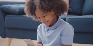 兴奋的黑人女孩在智能手机上玩游戏，使用移动应用程序和微笑