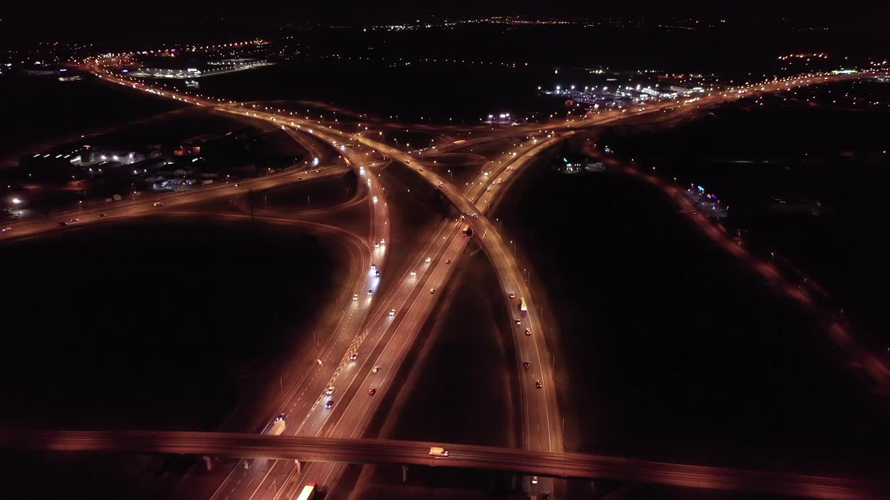 从无人机的角度拍摄的一个巨大的立交桥网络的全景图，夜间交叉路口、十字路口、道路、桥梁等位于波兰华沙城外。