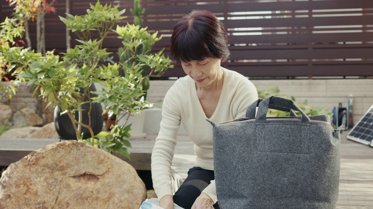 MLS-高级日本妇女添加土壤到一个家庭堆肥袋