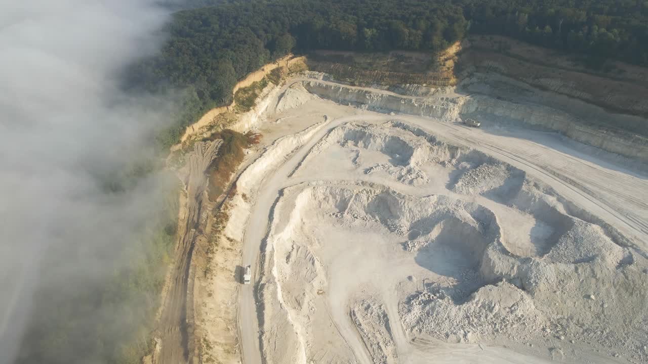 建筑工业用挖掘机和自卸卡车露天开采石灰石材料的鸟瞰图