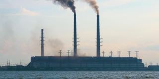 燃煤电厂的高管道，黑烟向上移动，污染大气。用化石燃料生产电能的概念