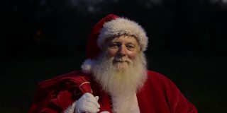 圣诞老人带着礼物袋的夜间特写镜头