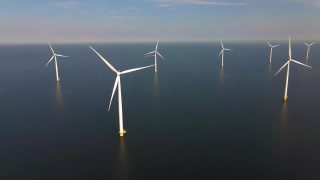 风力涡轮机在清晨，风车公园在荷兰。从空中看风力涡轮机，无人机在windpark westermeerdijk的一个风车农场在IJsselmeer湖最大的荷兰视频素材模板下载
