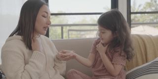 亚洲母亲和混合学前班女儿在家里玩挠痒痒游戏，家庭健康理念