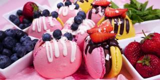 盒装甜品，手工制作的美味食品，马卡龙，巧克力装饰的新鲜草莓和蓝莓甜点，精致的黄色和粉红色蛋糕，糖和健康食品