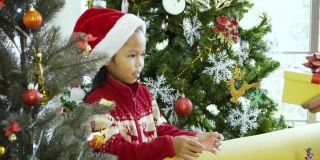亚洲可爱的小女孩收到来自她父母的礼品盒。