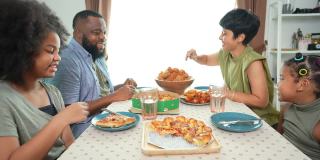 4K非洲混血家庭在家里一起吃炸鸡和披萨当晚餐