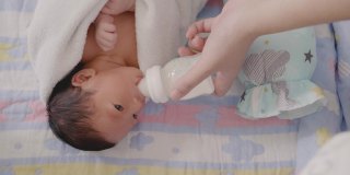 亚洲母亲正在给婴儿喂奶。