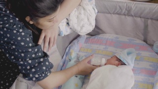 亚洲母亲喂婴儿的奶瓶男孩。视频素材模板下载