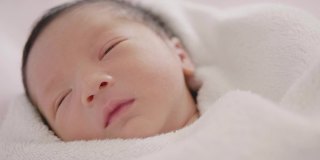 快乐亚洲可爱的儿子新生婴儿睡觉。新出生的。