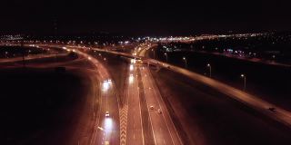 鸟瞰图的立交(交叉)与桥梁和高架桥，高速公路与坡道，繁忙的交通，在夜间。