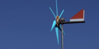 近距离的风力涡轮机与蓝天背景。概念自然与环境。