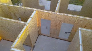 新建和现代化的模块化房屋。墙壁是由复合木面板制成的，里面有聚苯乙烯泡沫保温材料。构建节能家居理念的新框架视频素材模板下载