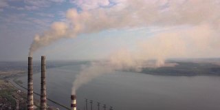 从火电厂冒灰烟的高高的烟囱管道鸟瞰图。用化石燃料发电