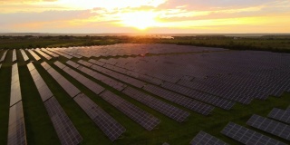 鸟瞰图的大型可持续发电厂与成排的太阳能光伏板生产清洁的生态能源在日落。零排放概念的可再生电力