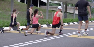 一群亚洲华人一起做弓步，慢跑前做热身运动