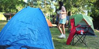 亚洲女孩在露营地露营期间与家人，徒步旅行的生活方式的概念。