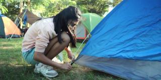 亚洲女孩在露营地露营期间与家人，徒步旅行的生活方式的概念。