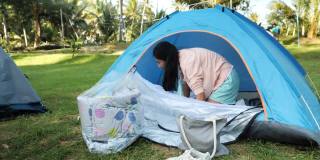 亚洲女孩准备帐篷露营期间与家人度假，徒步旅行的生活理念。