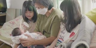 幸福的亚洲家庭与新生儿在家里。概念:新生活，儿子，家庭，家。
