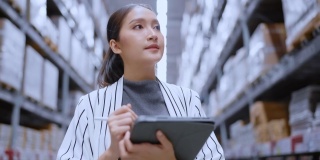 亚洲女企业主的肖像，使用数码平板电脑检查库存产品库存数量在配送仓库工厂。物流业务运输和配送服务