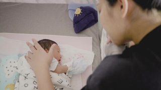 快乐的亚洲妈妈唱摇篮曲入睡。视频素材模板下载