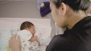 快乐的亚洲妈妈唱摇篮曲入睡。视频素材模板下载