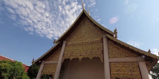 泰国寺庙的金色山墙顶端，装饰性的屋顶点与蓝天的平移视图。