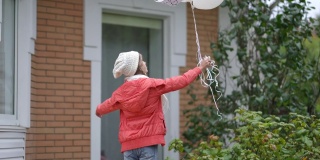 后视图十几岁的白人女孩在秋天春天的一天在户外与白色气球。自信的青少年女性生态活动家在后院与生态保护的象征