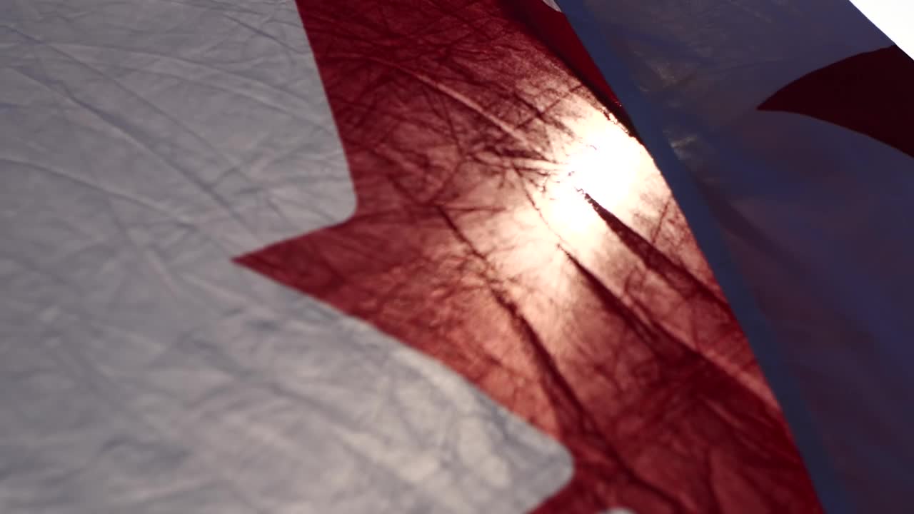 加拿大国旗迎风在夕阳下的自然背景与软焦点，慢动作。加拿大日的概念，国旗，北美，枫叶旗。