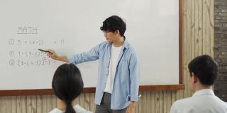 亚洲男教师在教室里教学生。
