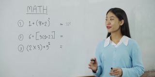 在教室里教学生的亚洲女教师。