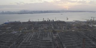 日落时分，一座大型城市建筑群的施工现场，天空中浪漫的彩云