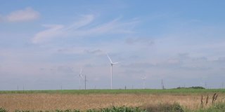 风力发电机在农场的农田里运转